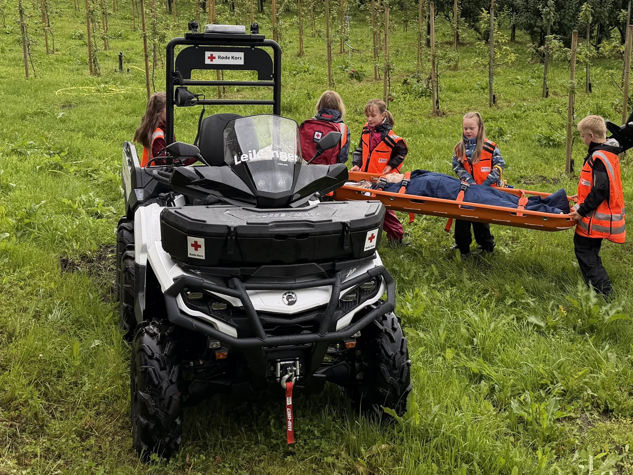 Barna fraktar den «sakna» personen på båre fram til ATV-en under aktivitetsdagen.